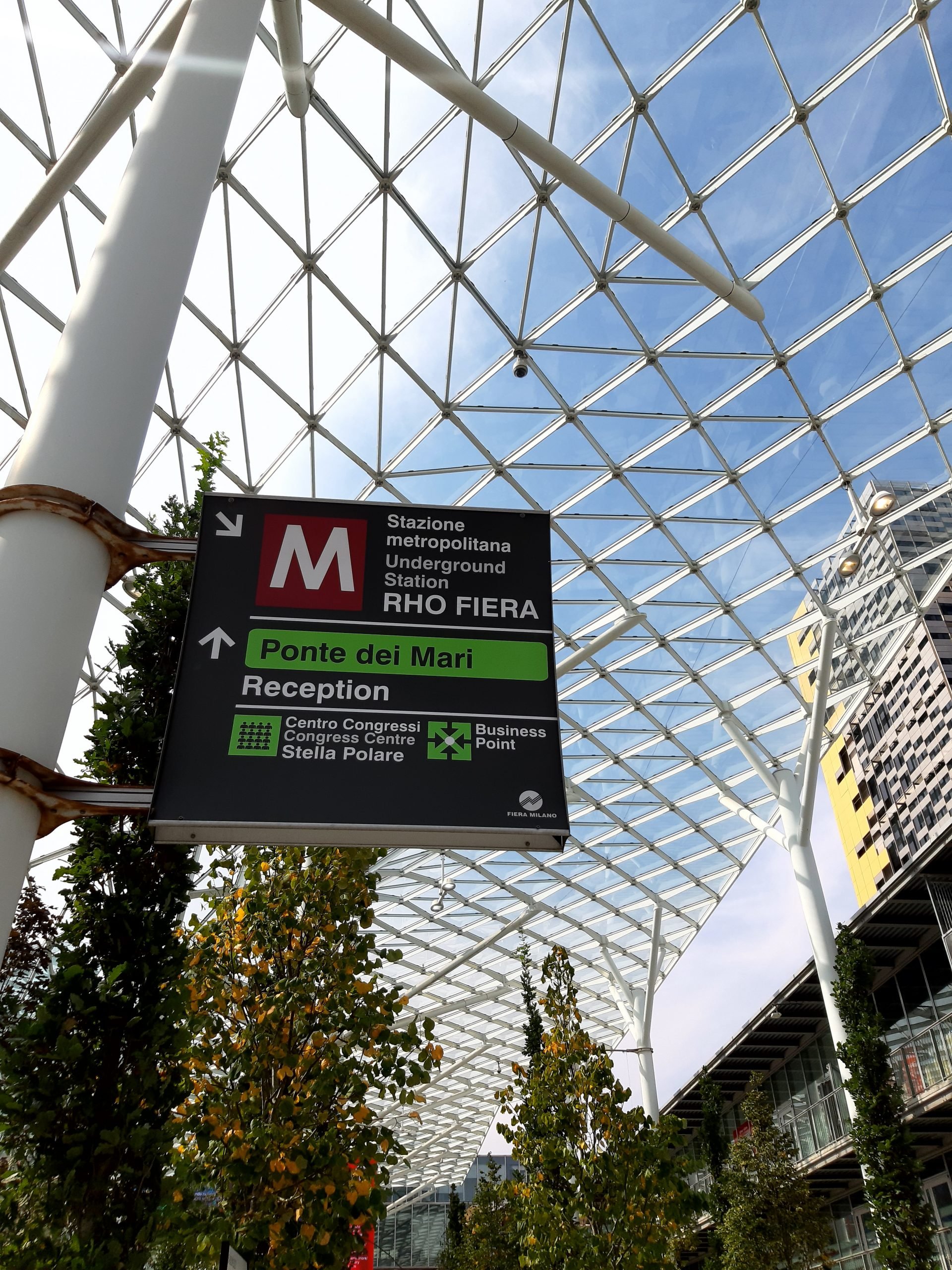 Entrada da feira do Salão de Móveis de Milão 2021 com corredor verde de árvores
