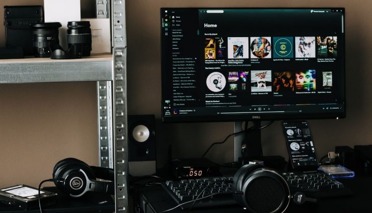 Analista de marketing subindo o podcast para o Spotify Imagem de um mini estúdio caseiro.