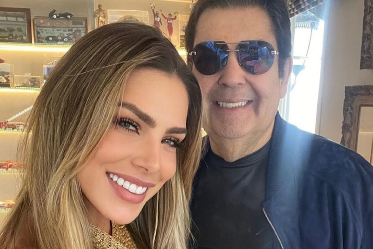 Na foto, Erika está do lado esquerdo, com cabelos loiros, sorrindo para foto. Ao seu lado direito, está Faustão, de óculos escuro e casaco preto, sorrindo também. Erika se despediu de Fausto Silva no Instagram
