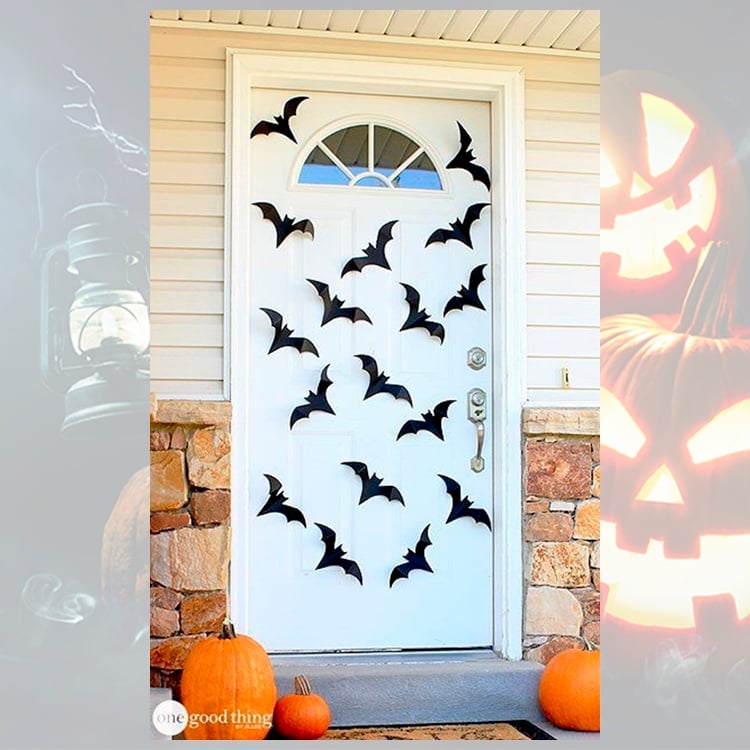 Foto de decoração para o Dia das Bruxas com morcegos e abóboras na porta
