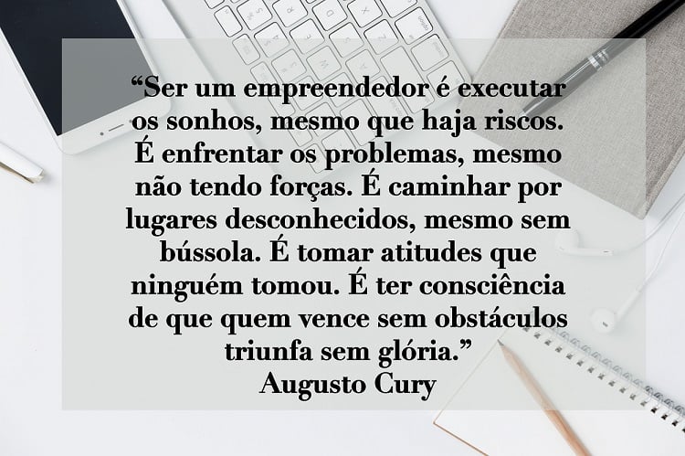 Frase de Dia do Empreendedor de Augusto Cury escrita em foto de mesa de trabalho