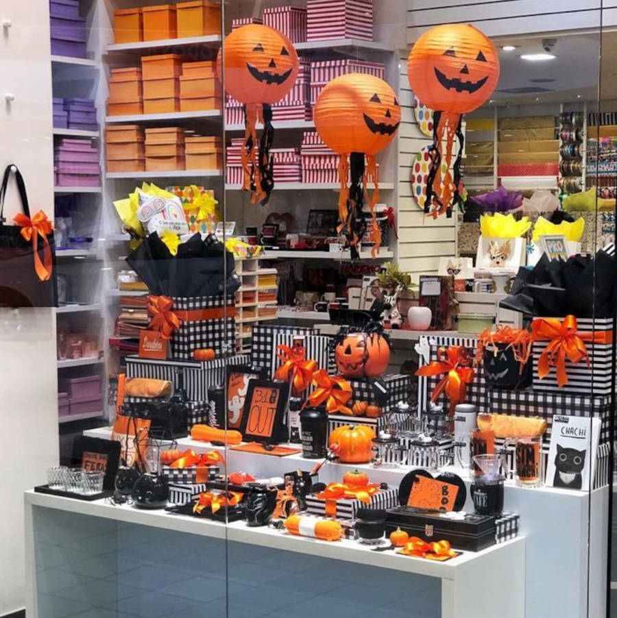 Foto de vitrine de Halloween com decoração laranja e preto e elementos de abóbora