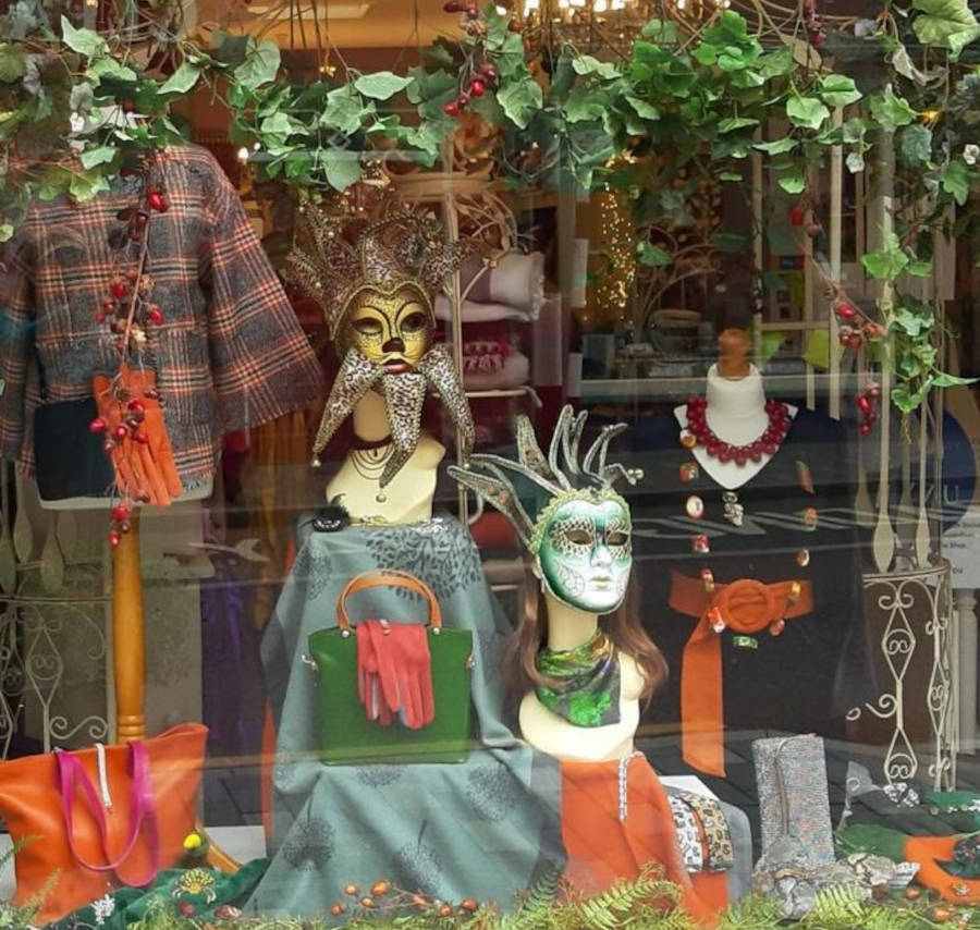 Foto de vitrine de loja com bolsas, roupas e máscaras para o Halloween