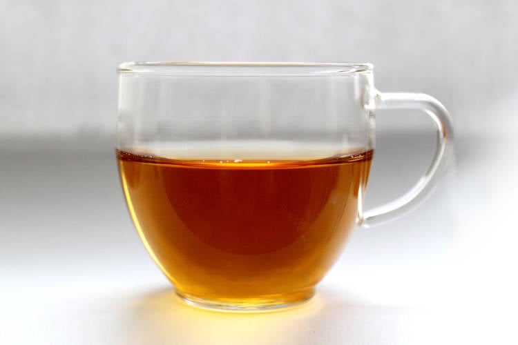 foto de xícara de vidro com chá de boldo