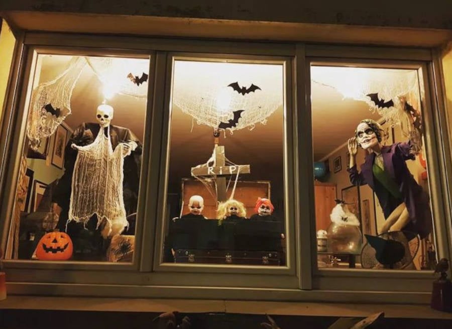 Foto de vitrine de Halloween com decoração com luminária e morcegos no vidro