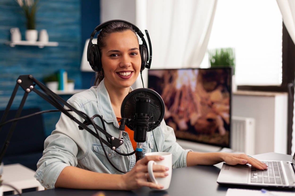 Foto de mulher em frente a microfone para criar um podcast