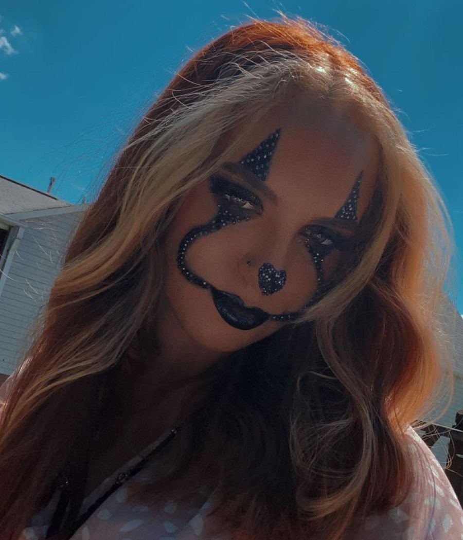 Garota com maquiagem de halloween simples, usando pedrarias pretas para imitar palhaçop