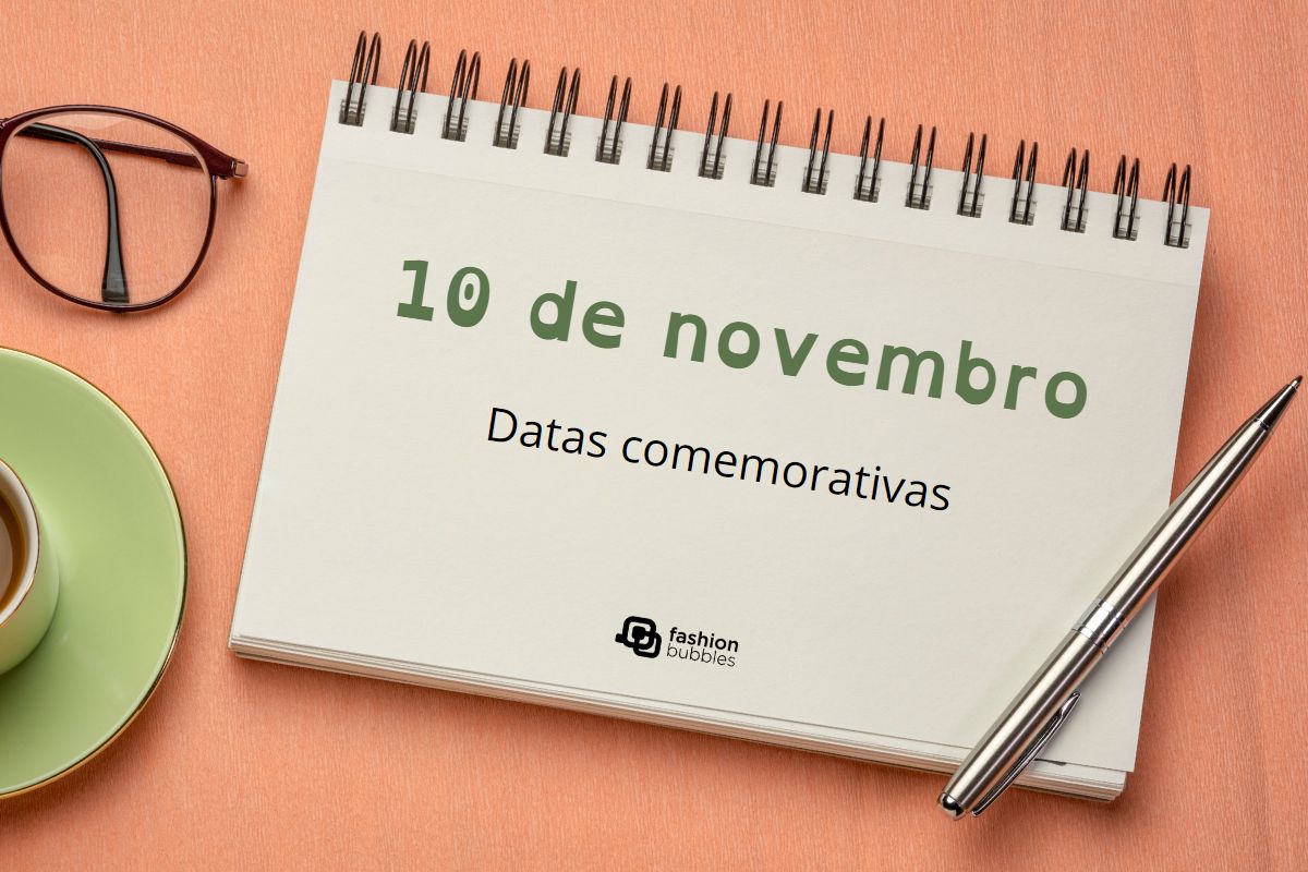 Imagem em fundo laranja com óculos, xícaras e caderno. No caderno lê-se em verde "10 de novembro", e em preto "Datas Comemorativas". Abaixo logotipo do Fashion Bubbles.