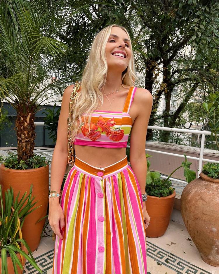 Estampas verão 2022;mulher usa conjunto com estampa de listras coloridas Estampas verão 2022