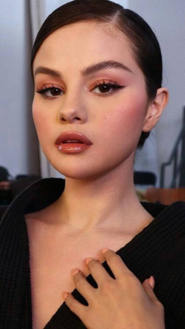 Selena Gomez com maquiagem em tom pêssego e gloss