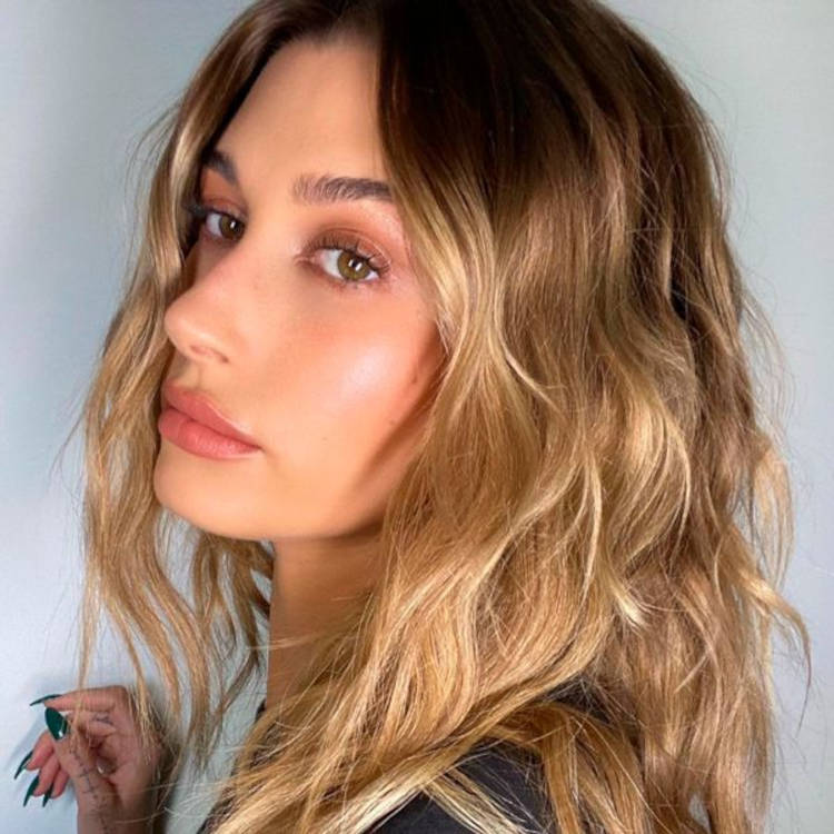 Hailey Bieber de sombra terrosa clara e gloss