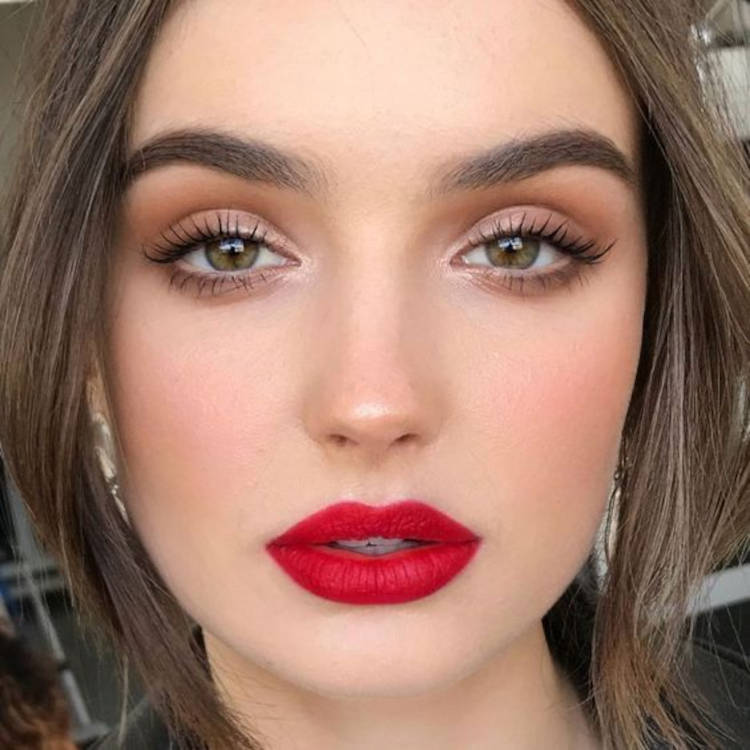 Mulher de pele clara com sombra nude e batom vermelho