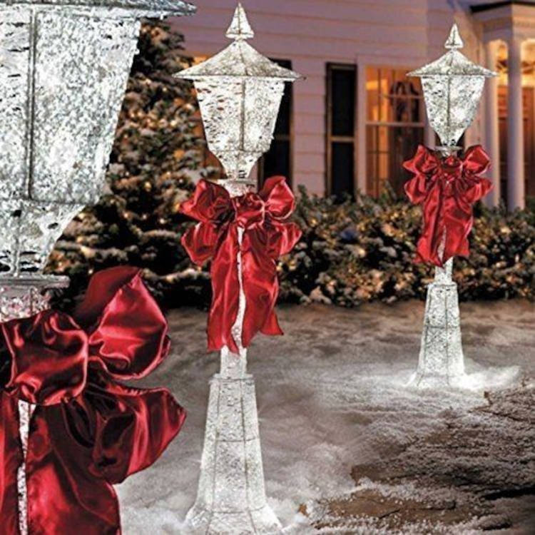 Luminárias com laços vermelhos. Decoração de natal para jardim com tema de gelo.