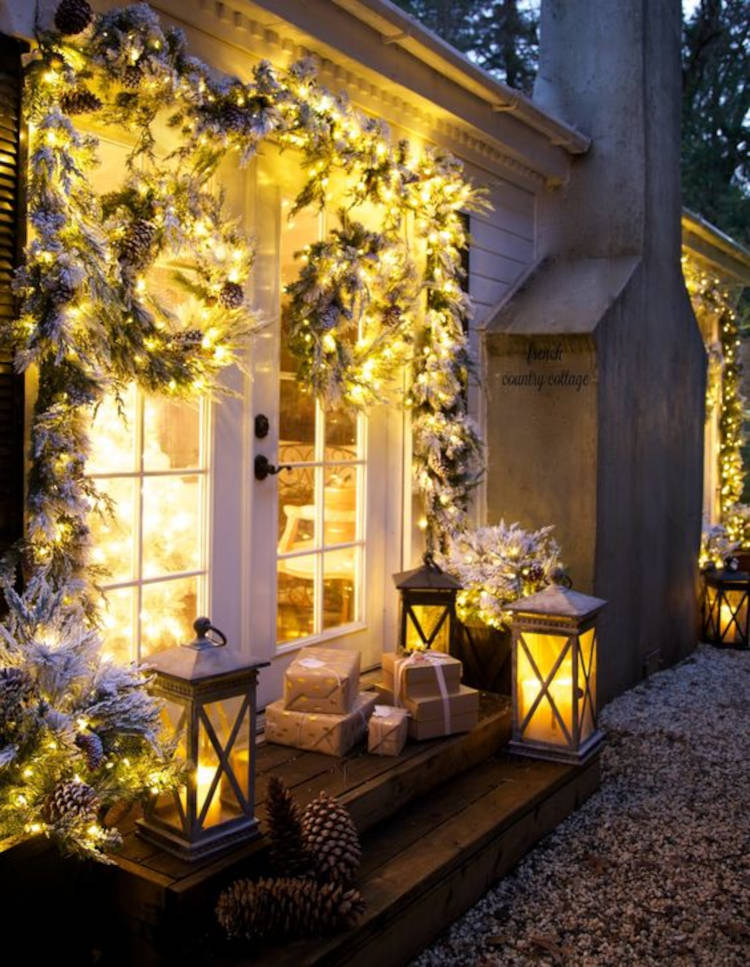 Ramos de folhas e pinhas na janela. Decoração de natal para jardim com pisca-pisca e presentes.