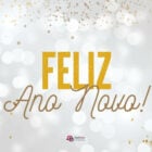 Foto de luzes prateadas com a frase "Feliz Ano Novo" escrito em dourado