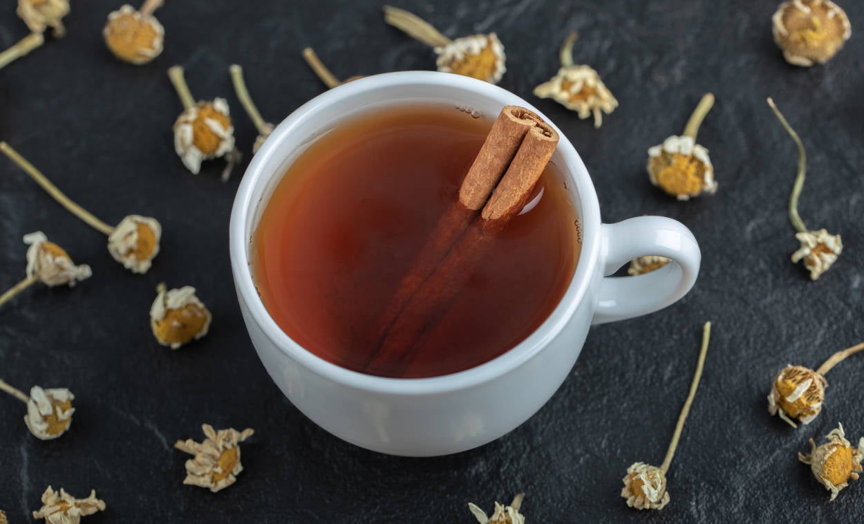 foto de chá de canela em xícara branca