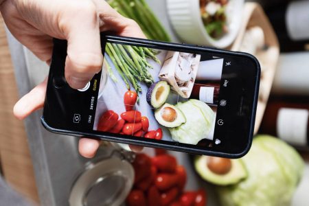 Pessoa tirando fotos de alimentos anti-inflamatórios.