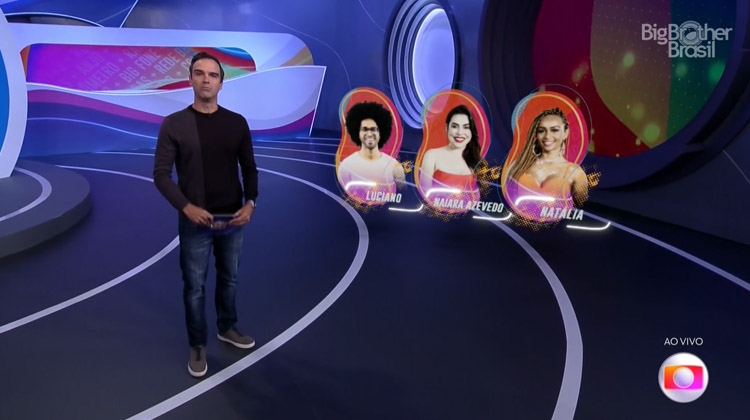 Tadeu em pé no estúdio com as fotos de Luciano, Naiara e Natália atrás. Primeiro paredão foi formado no BBB 22