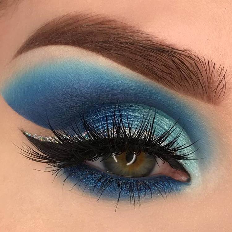 Make com sombra azul colorida. Foto de modelo com maquiagem sombra azul.