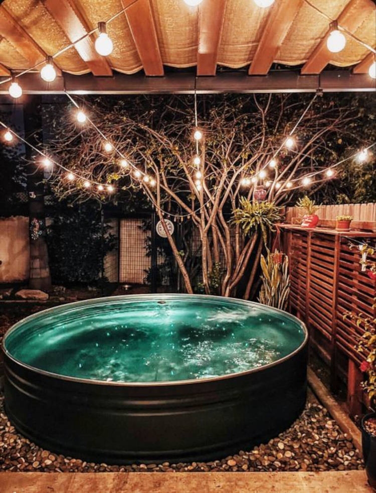 Quintal com varal de luzes e piscina redonda. Tanque preto como piscina redonda.