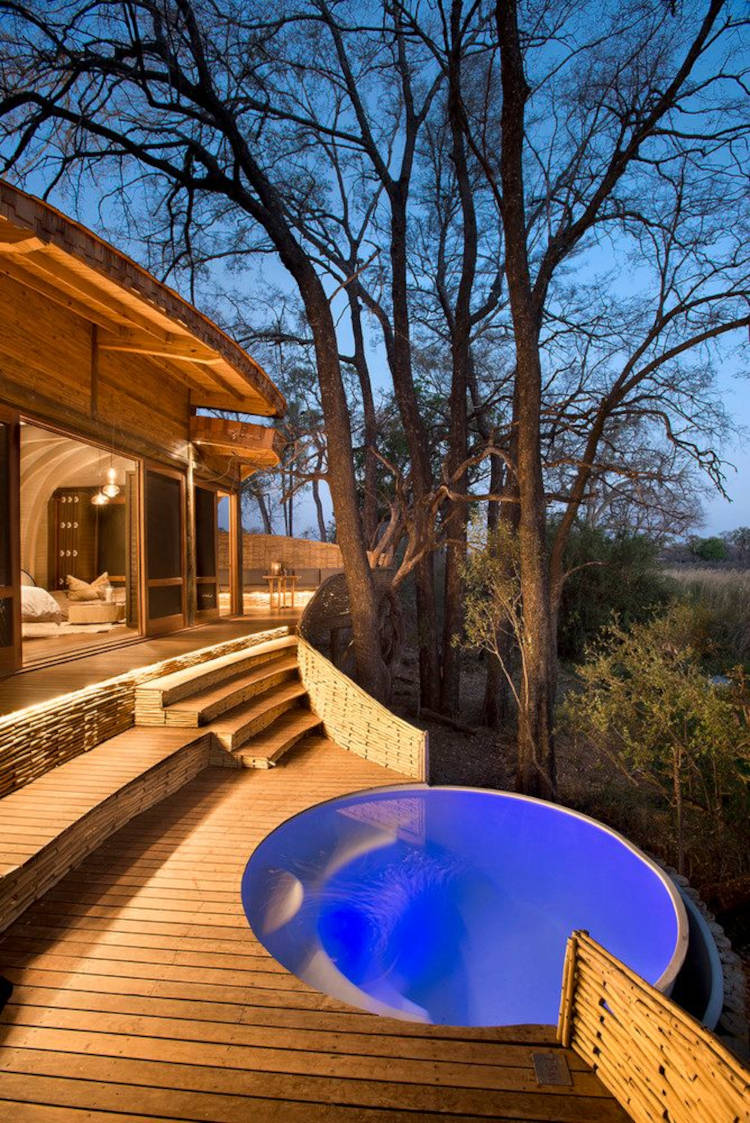Casa de madeira com piscina. Piscina redonda com borda infinita.