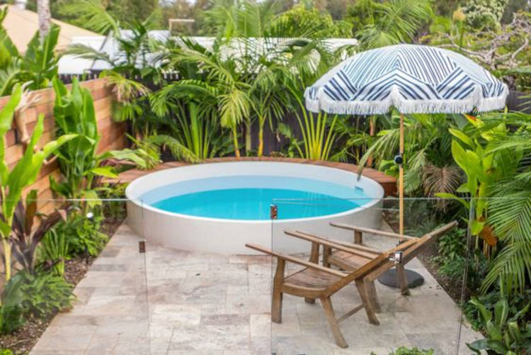 Piscina redonda pequena. Quintal pequeno com jardim.