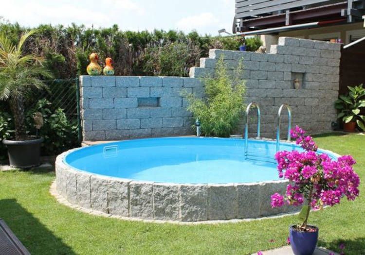 Piscina redonda de fibra e pedra. Revestimento externo com pedra.