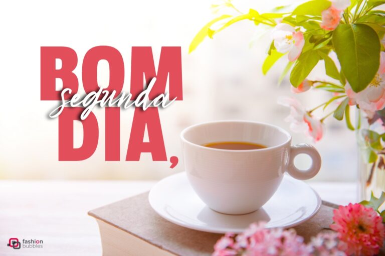 Foto de xícara de café em superfície de madeira com flores ao redor e escrito Bom Dia, Segunda
