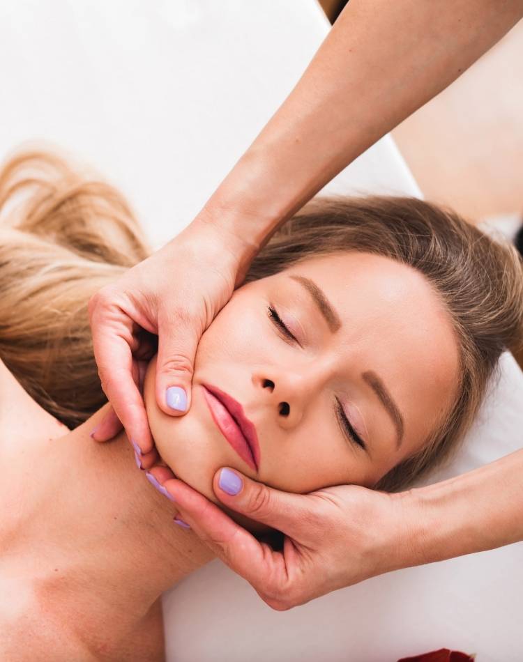 Mulher fazendo massagem na mandíbula para tratar o bruxismo Mulher fazendo massagem