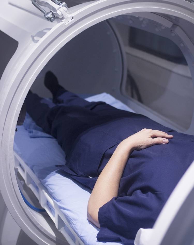 Tratamento com oxigenoterapia. Pessoa dentro de câmara hiperbárica.