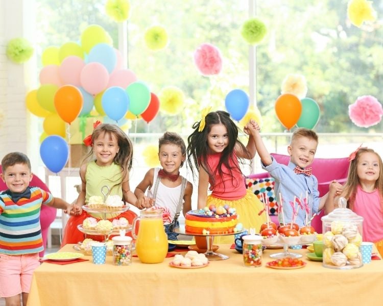 Foto de crianças com comidas em festa infantil.