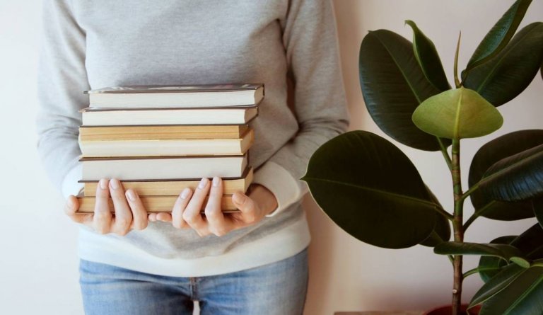 Foto de mulher segurando livros.