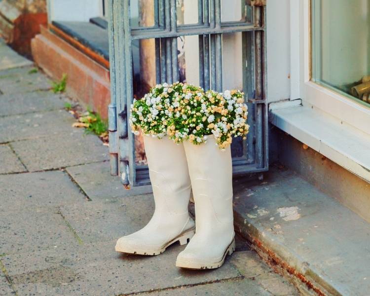 Foto de botas de galocha como vasos de flor.