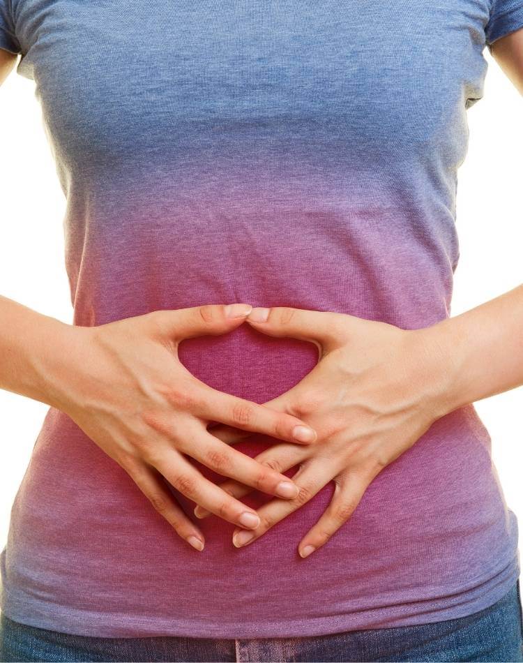 Chá de arruda pode causar dores. Mulher com dores abdominais.
