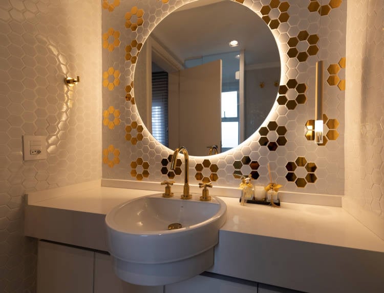 Banheiro branco com golden decor.