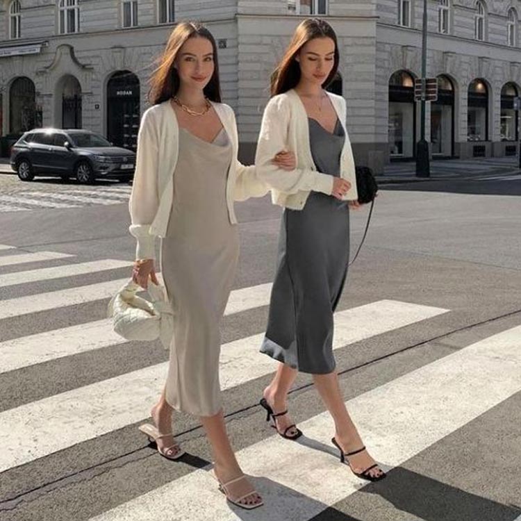 duas mulheres usam looks com cardigan branco e slip dress cinza