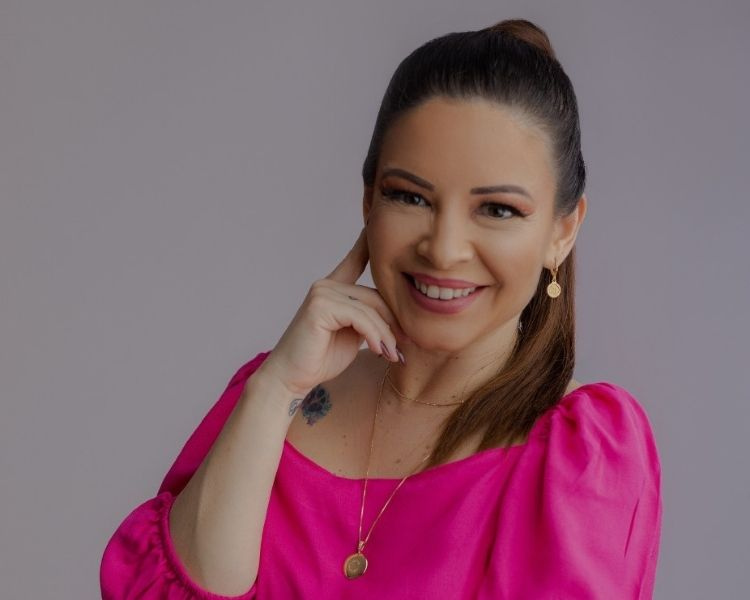 foto da terapeuta Camila Custódio usando blusa rosa e colar dourado