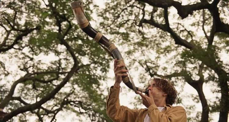 Jove tocando berrante, em Pantanal