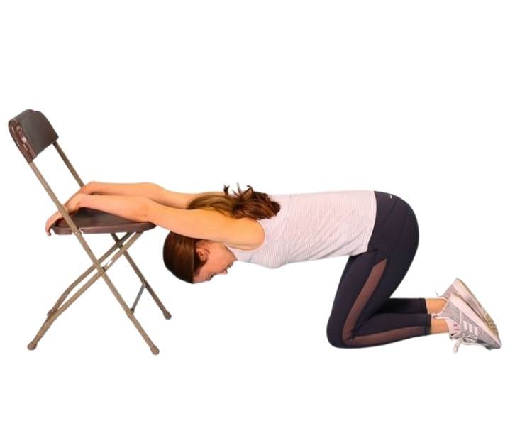 Foto mulher fazendo exercício grande dorsal com cadeira.