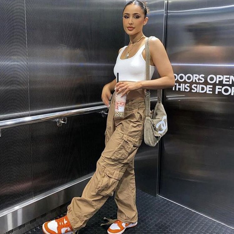 mulher em um elevador usando look com regata branca