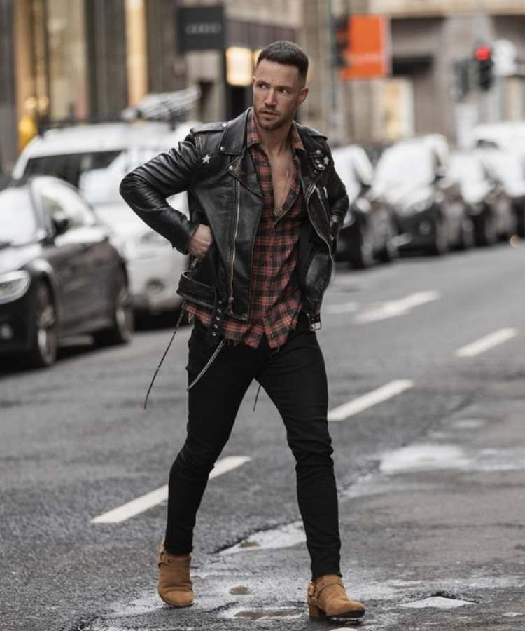 Foto de modelo com Camisa xadrez + jaqueta de couro + calça jeans + bota cano curto - Moda masculina de São João.