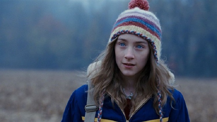 Cena do filme Um olhar do paraíso: uma menina em um local aberto com roupas de frio Atriz Saoirse Ronan em cena de "Um Olhar do Paraíso" filmes sobre espiritualidade