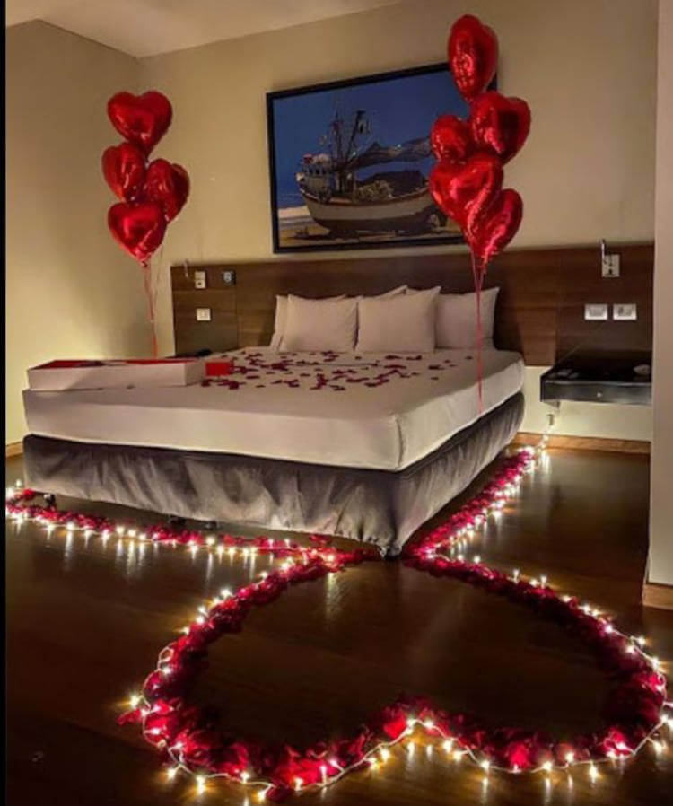 Coração com velas no chão em quarto romântico.
