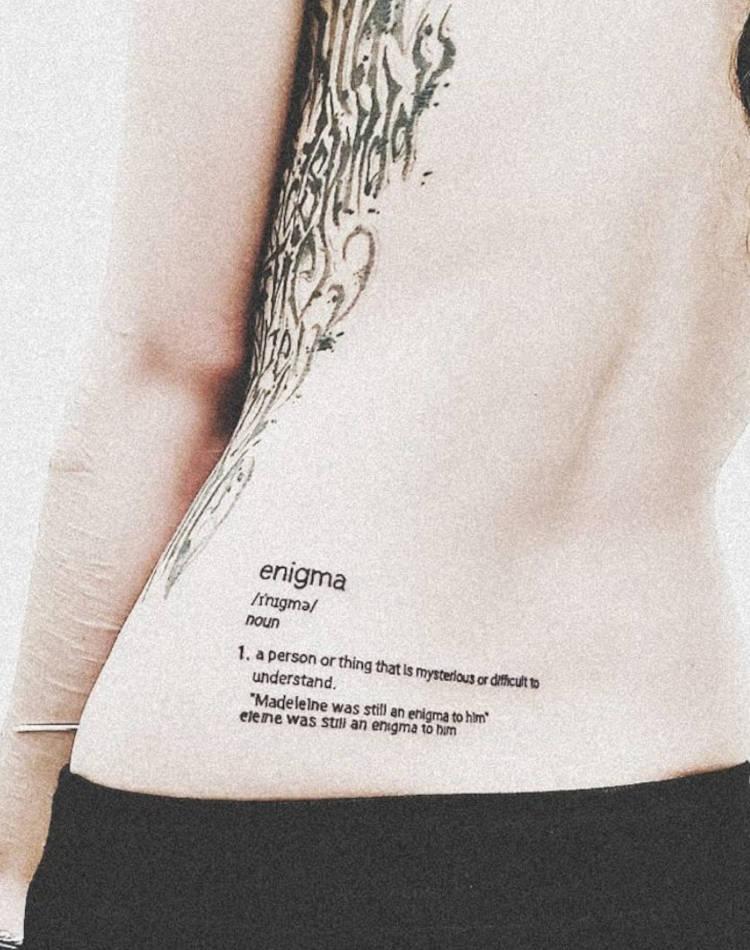 Tatuagem com frase na parte de trás da cintura