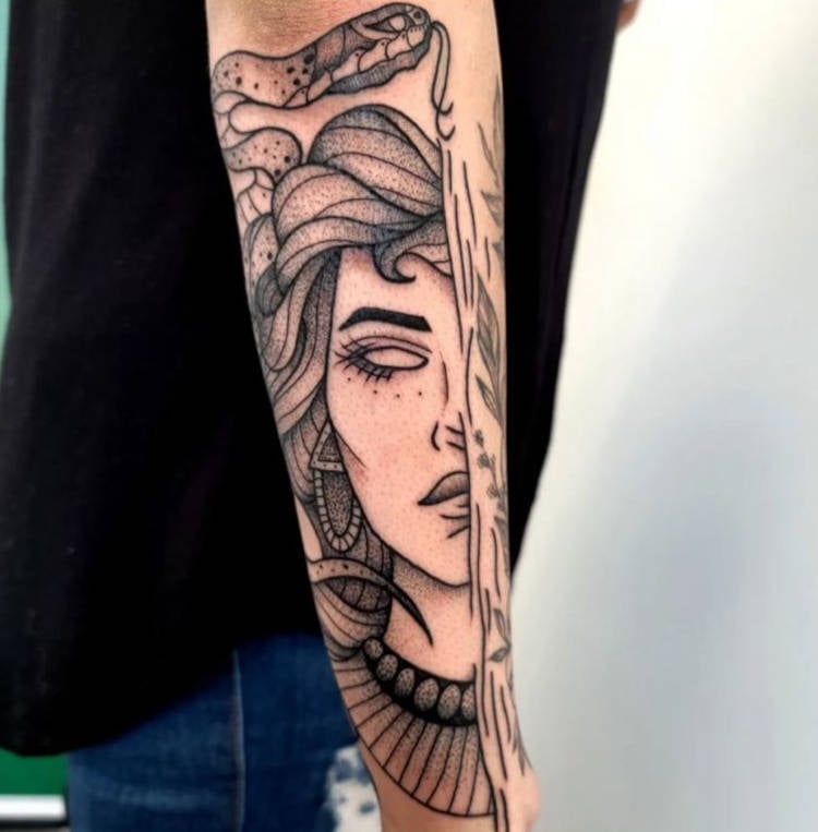 Tatuagem com metade do rosto de medusa no braço