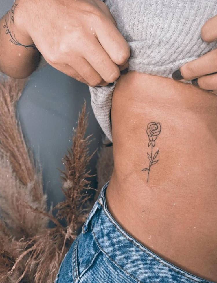 Tatuagem de flor na costela pequena