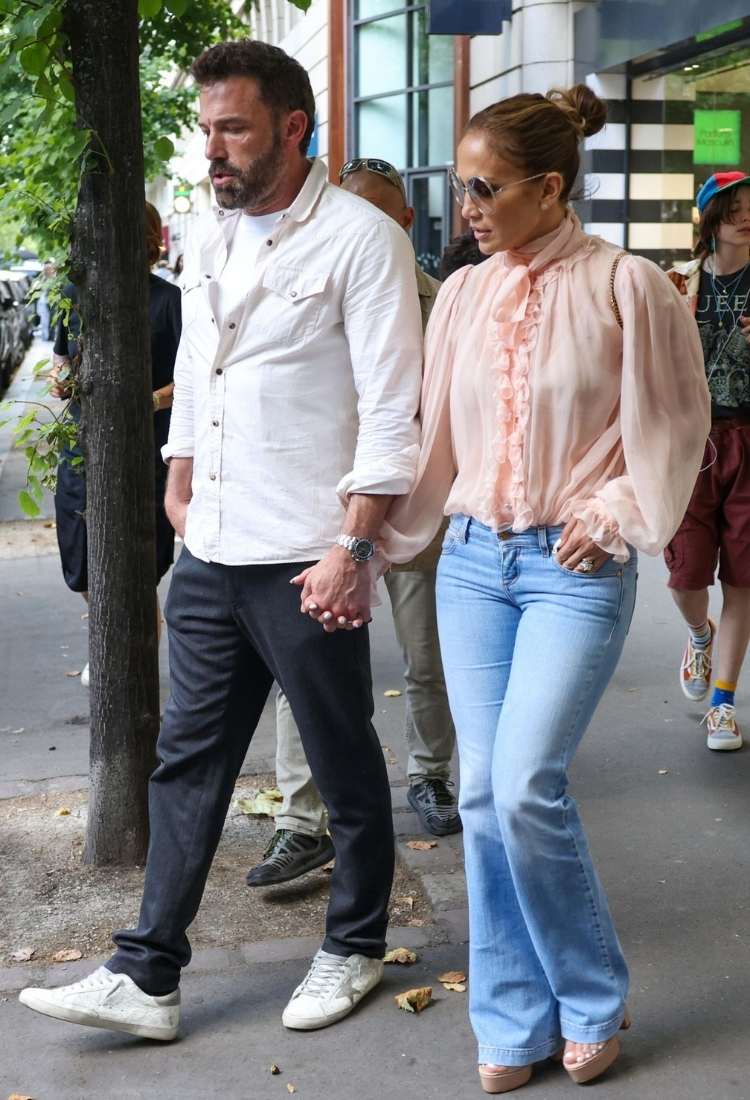 A cantora Jennifer Lopes elegante em uma blusa de babados e jeans de lavagem clara enquanto ela e o ator Affleck passeavam em Paris.