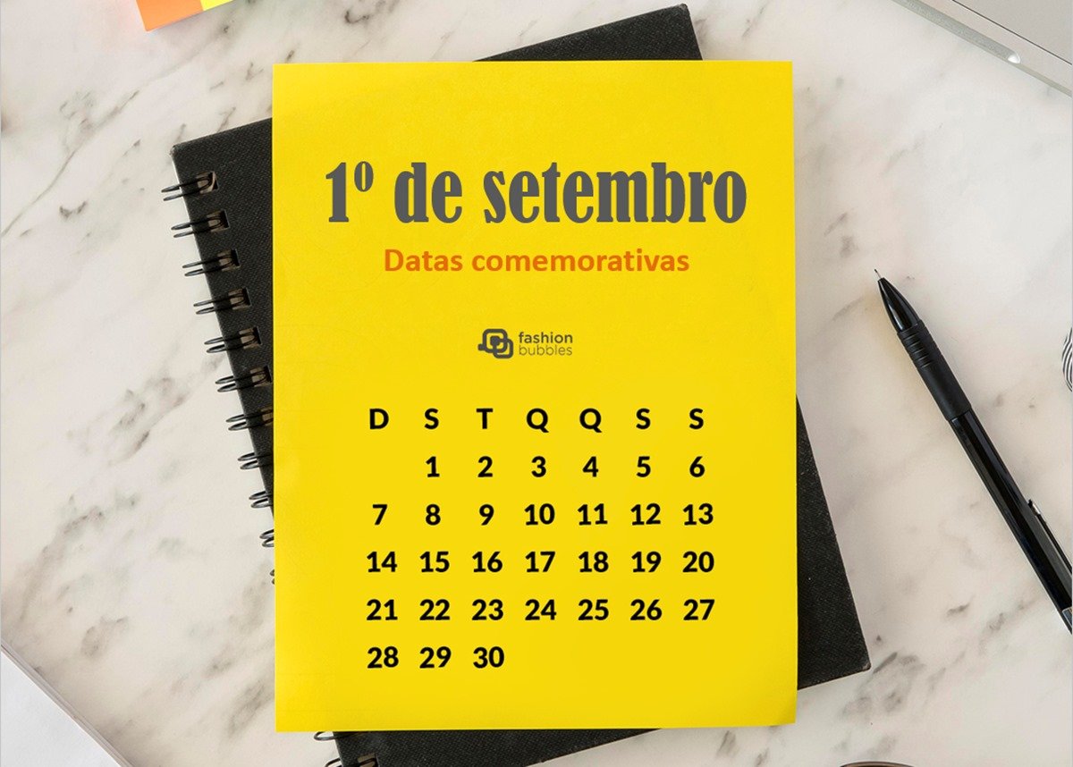 Foto de calendário amarelo com a data 1º de setembro. Ele está sobre um caderno preto, que est´em uma superfície de mármore. Tem também uma caneta preta ao lado do calendário.