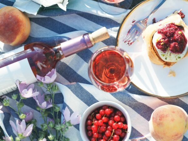 foto de piquenique com garrafa de vinho, flores, frutas e bruschetta