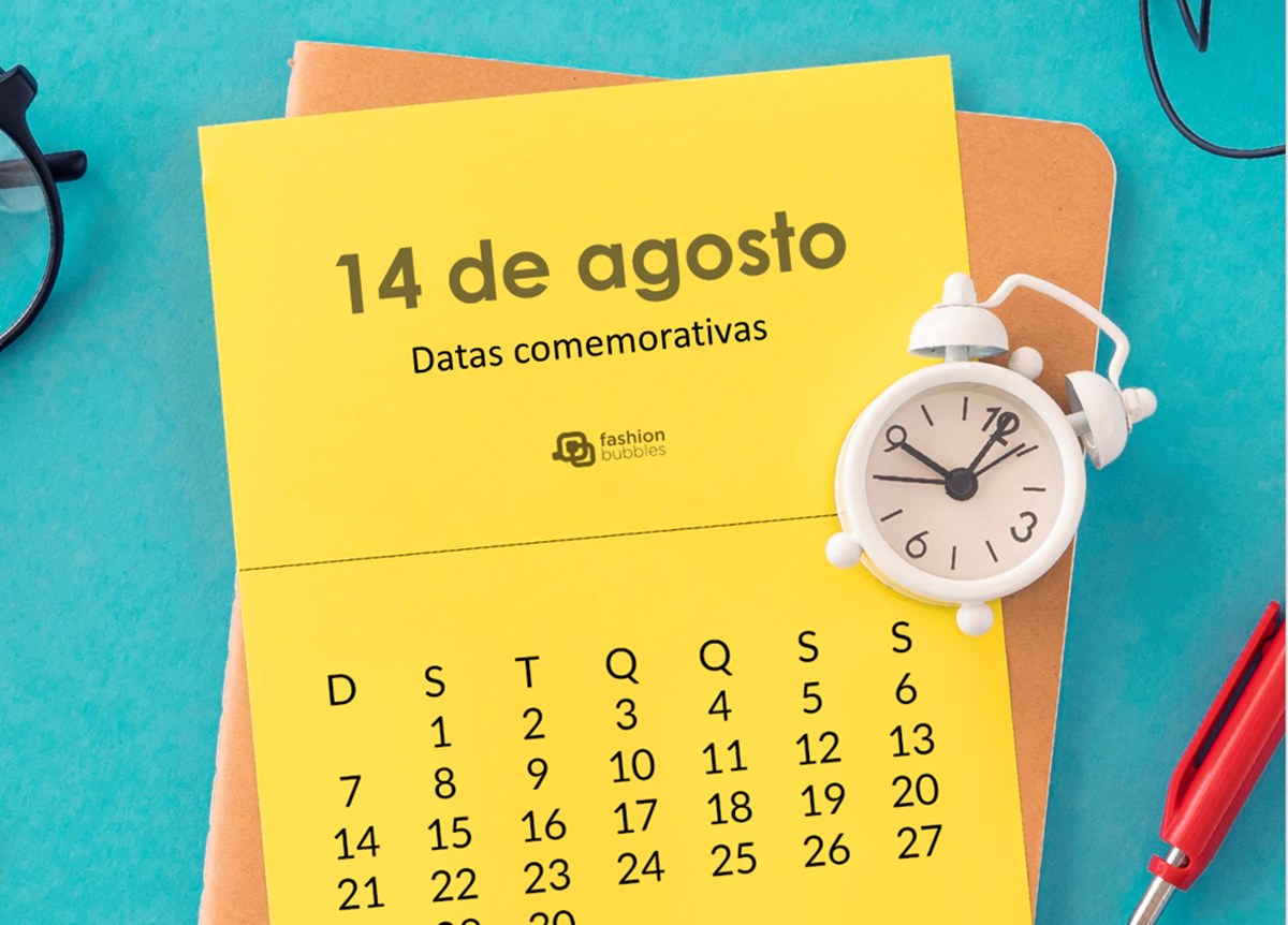 Foto de calendário sobre mesa com objetos como despertador e caneta, com a data 14 de agosto escrita.
